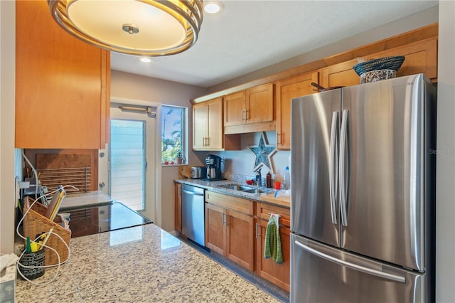 kitchen featuring light stone countertops, appliances with stainless steel finishes, and sink