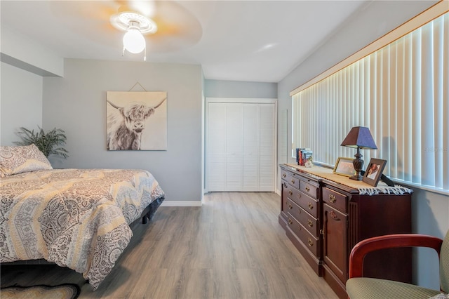 bedroom featuring ceiling fan, light wood-type flooring, and a closet