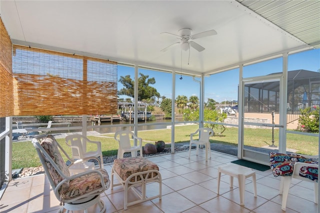 sunroom featuring a water view and ceiling fan