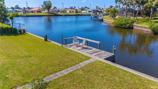 dock area with a water view and a lawn