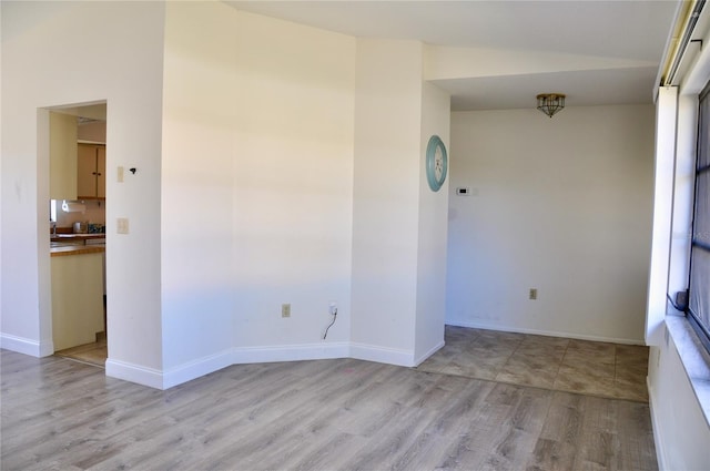 spare room with light wood-style flooring and baseboards