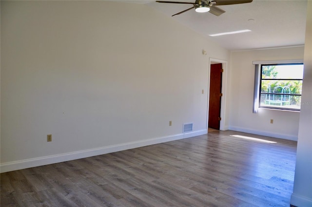 unfurnished room featuring visible vents, a ceiling fan, vaulted ceiling, wood finished floors, and baseboards