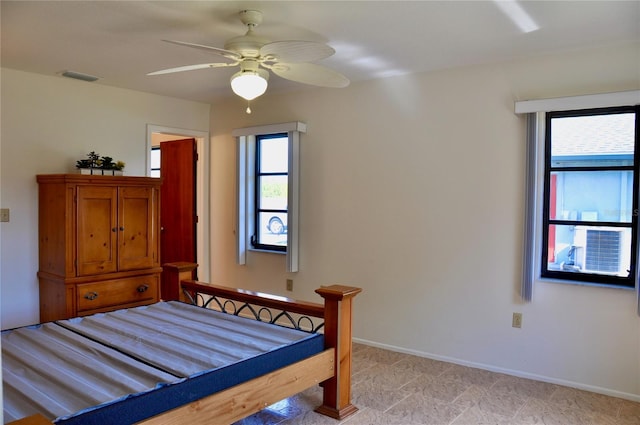 bedroom featuring ceiling fan, multiple windows, visible vents, and baseboards