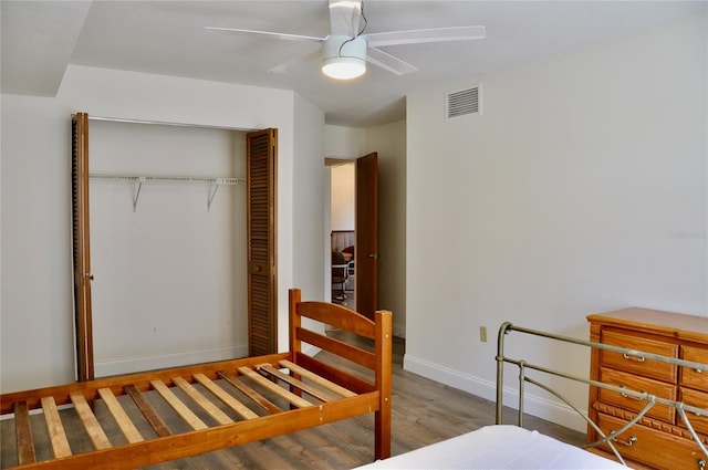 bedroom with light wood finished floors, a closet, visible vents, ceiling fan, and baseboards