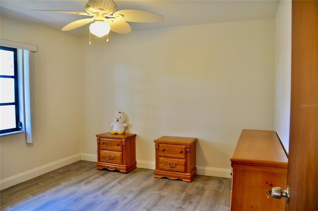 misc room with light wood-type flooring, a ceiling fan, and baseboards