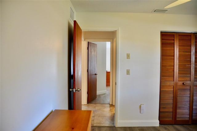 unfurnished bedroom with a closet, visible vents, light wood-style flooring, and baseboards