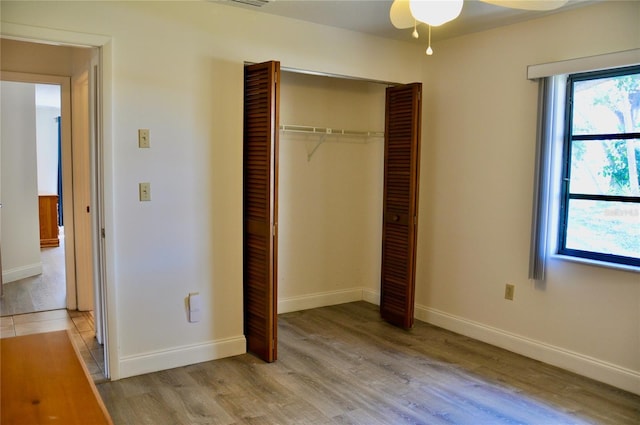 unfurnished bedroom with a closet, visible vents, light wood-style flooring, and baseboards