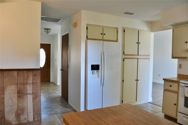 kitchen featuring visible vents, white refrigerator with ice dispenser, light tile patterned flooring, and electric range