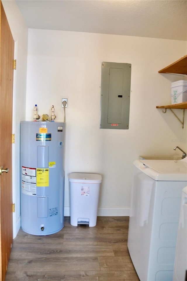 utility room with electric panel, a sink, and electric water heater