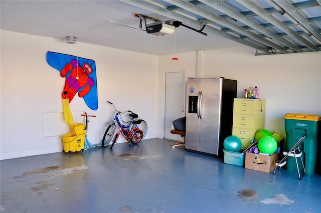 garage with baseboards, stainless steel refrigerator with ice dispenser, and a garage door opener