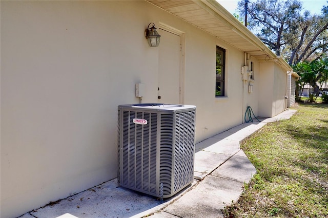 exterior details with central AC unit and stucco siding