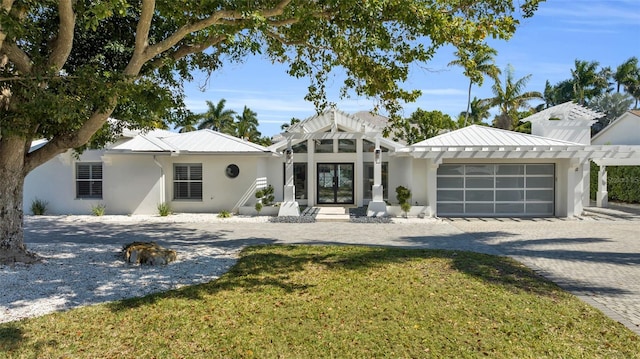 view of front of property with french doors, a garage, and a front yard