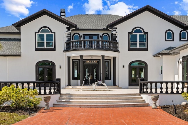 view of front of house with sink, french doors, and a balcony