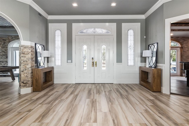 entryway featuring ornamental molding and light hardwood / wood-style floors