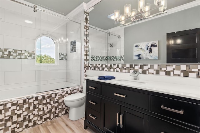 full bathroom with hardwood / wood-style floors, vanity, tiled shower / bath, toilet, and tasteful backsplash