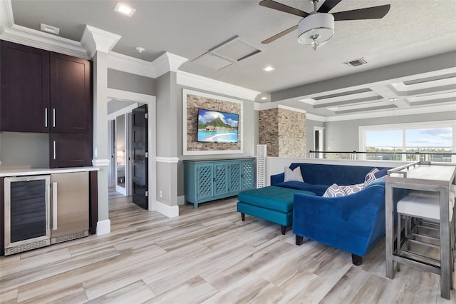 living room featuring beamed ceiling, light wood-type flooring, coffered ceiling, and wine cooler