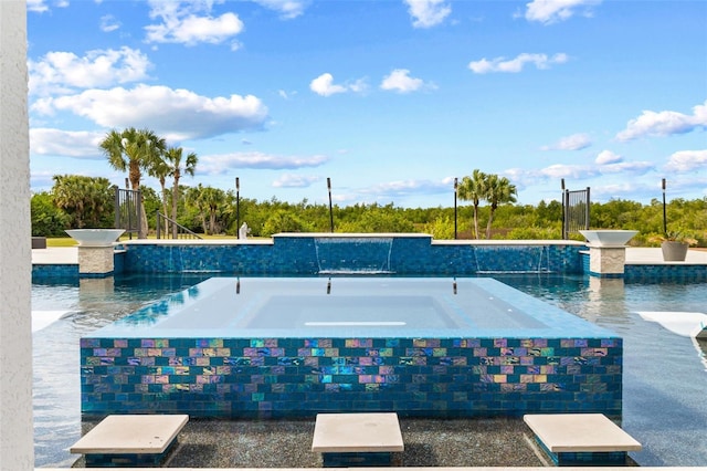 view of pool with a hot tub