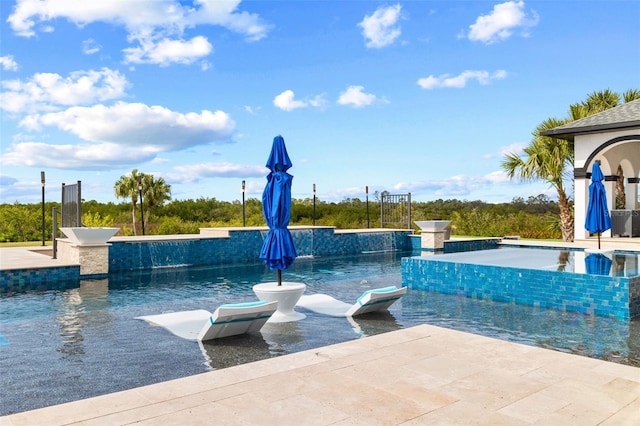 view of swimming pool featuring pool water feature and a patio area