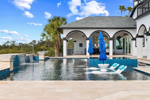 view of swimming pool with a patio, an outbuilding, and pool water feature