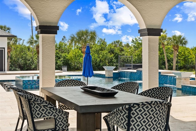 view of patio / terrace featuring a swimming pool with hot tub and a bar