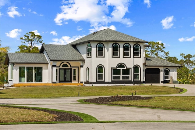 view of front of home with french doors, a front yard, and a garage