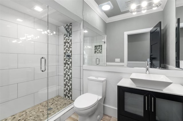 bathroom with vanity, crown molding, toilet, and a shower with door