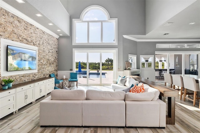 living room featuring french doors, a towering ceiling, and light hardwood / wood-style flooring