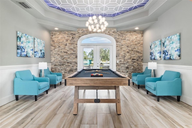 recreation room with a tray ceiling, french doors, pool table, and wood-type flooring