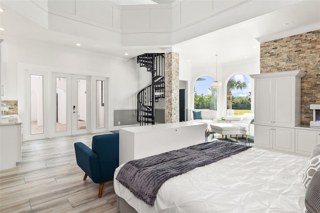 bedroom featuring a high ceiling and light wood-type flooring