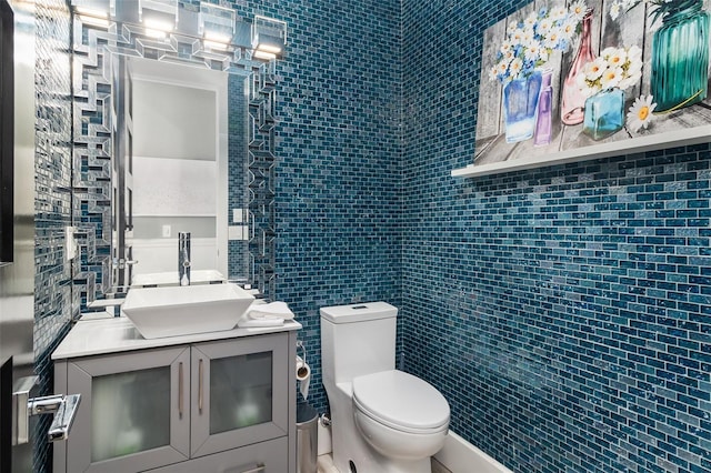 bathroom featuring tile walls, toilet, and vanity