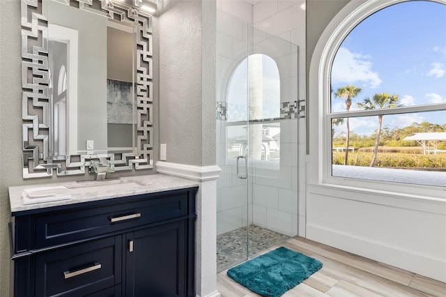 bathroom featuring vanity, an enclosed shower, and wood-type flooring