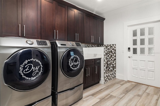 clothes washing area featuring cabinets, light hardwood / wood-style floors, and independent washer and dryer