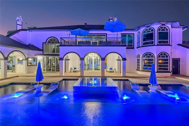 pool at dusk with a patio area