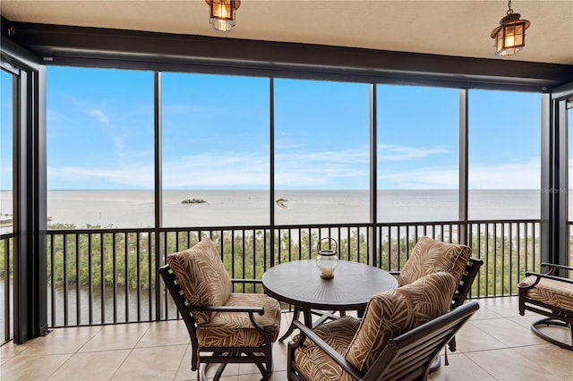 sunroom with a view of the beach and a water view