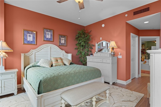 bedroom with ceiling fan, light wood-style flooring, visible vents, and baseboards