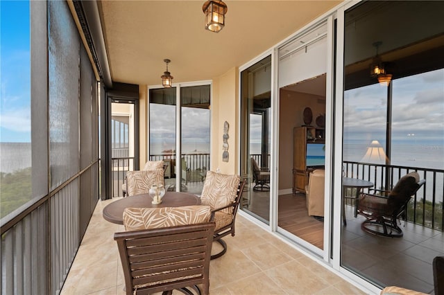 sunroom featuring a water view