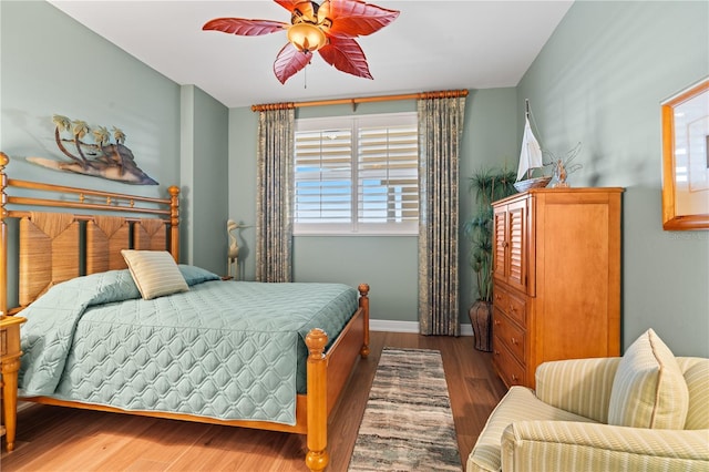 bedroom with ceiling fan, baseboards, and wood finished floors