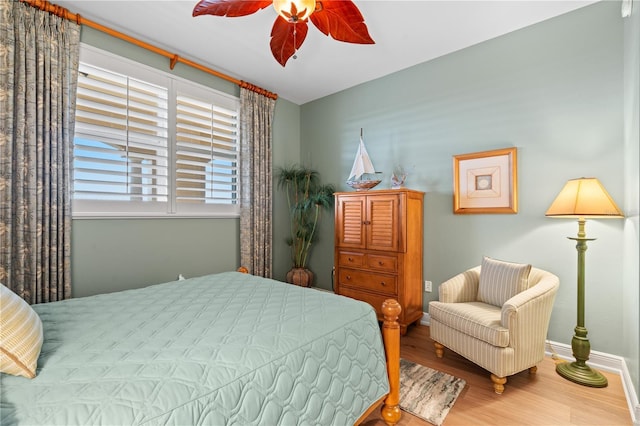 bedroom featuring ceiling fan, baseboards, and wood finished floors