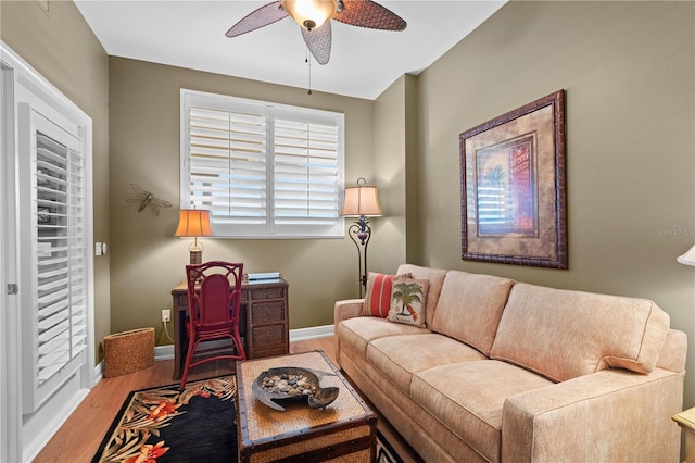 living area featuring ceiling fan, baseboards, and wood finished floors