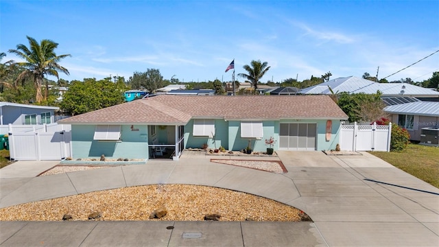 ranch-style house featuring concrete driveway, a gate, and stucco siding