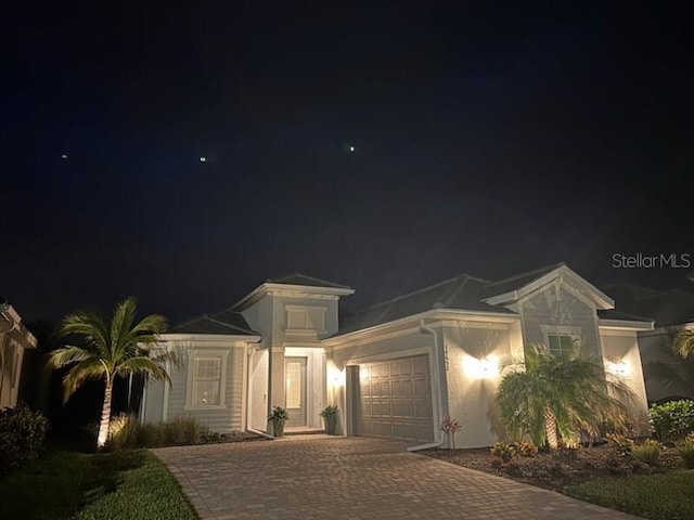 mediterranean / spanish-style home with an attached garage and decorative driveway