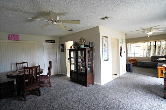 carpeted dining area featuring a textured ceiling and ceiling fan