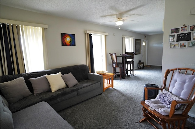 living room with ceiling fan, carpet floors, and a textured ceiling