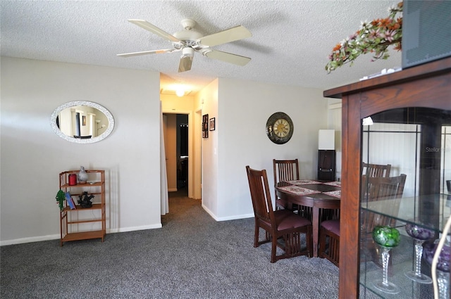 dining area with dark colored carpet, ceiling fan, and a textured ceiling