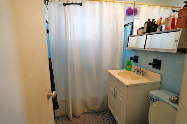 bathroom featuring a shower with curtain, vanity, toilet, and tile walls