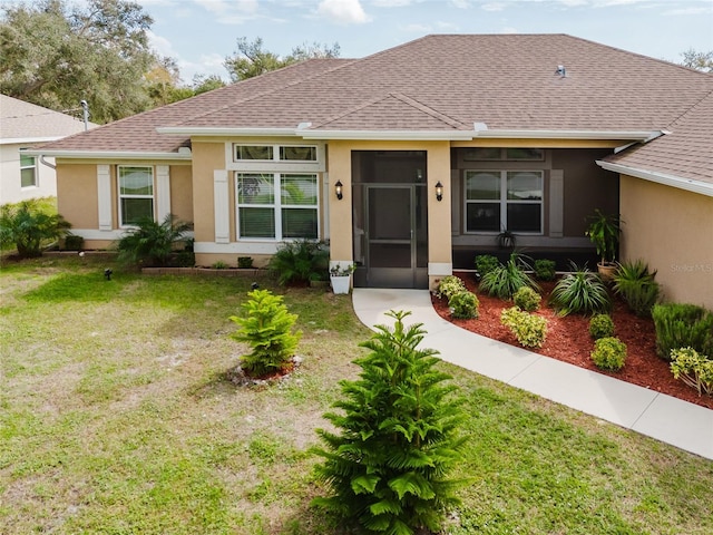 view of front of home featuring a shingled roof, a front lawn, and stucco siding