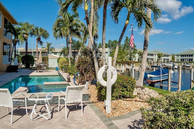 view of pool with a water view and a patio area