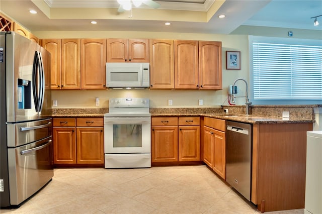 kitchen featuring stainless steel appliances, crown molding, and a tray ceiling