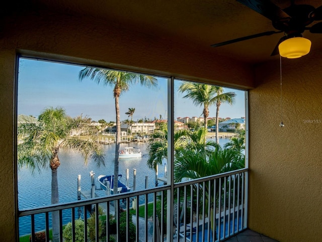 balcony with a water view and ceiling fan