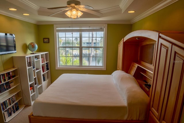 bedroom featuring a raised ceiling, crown molding, and carpet